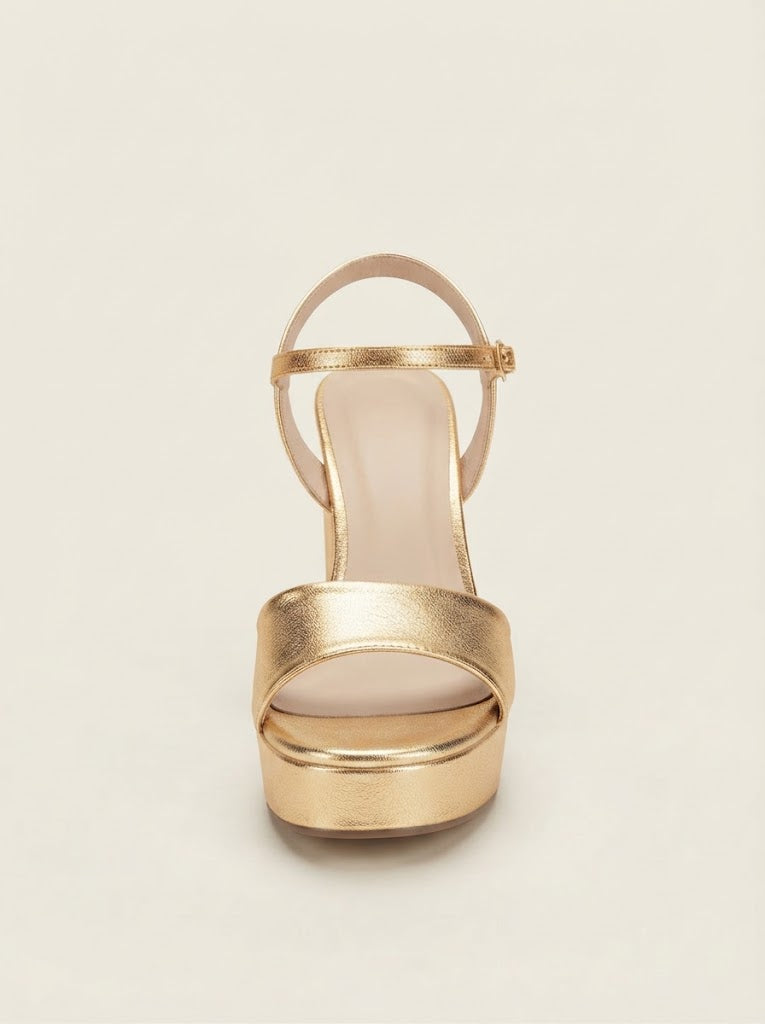 A single metallic gold platform sandal with an ankle strap, shown from a front-facing perspective on a light beige background.
