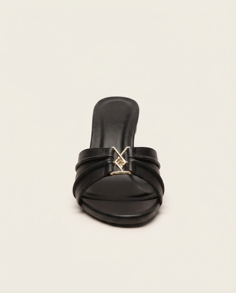 A single black leather slide sandal with a low block heel and a gold-tone metal LV monogram buckle at the center, shown against a plain off-white background.