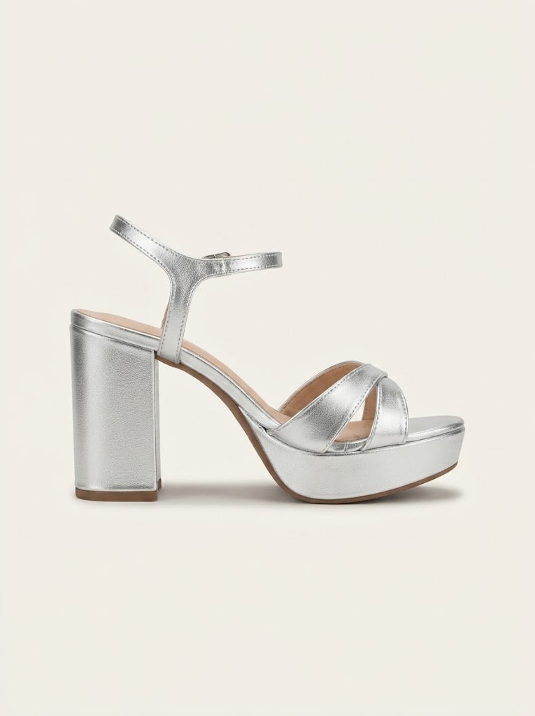 A single metallic silver platform sandal with a block heel, open toe, and ankle strap, shown from a side profile on a light beige background.