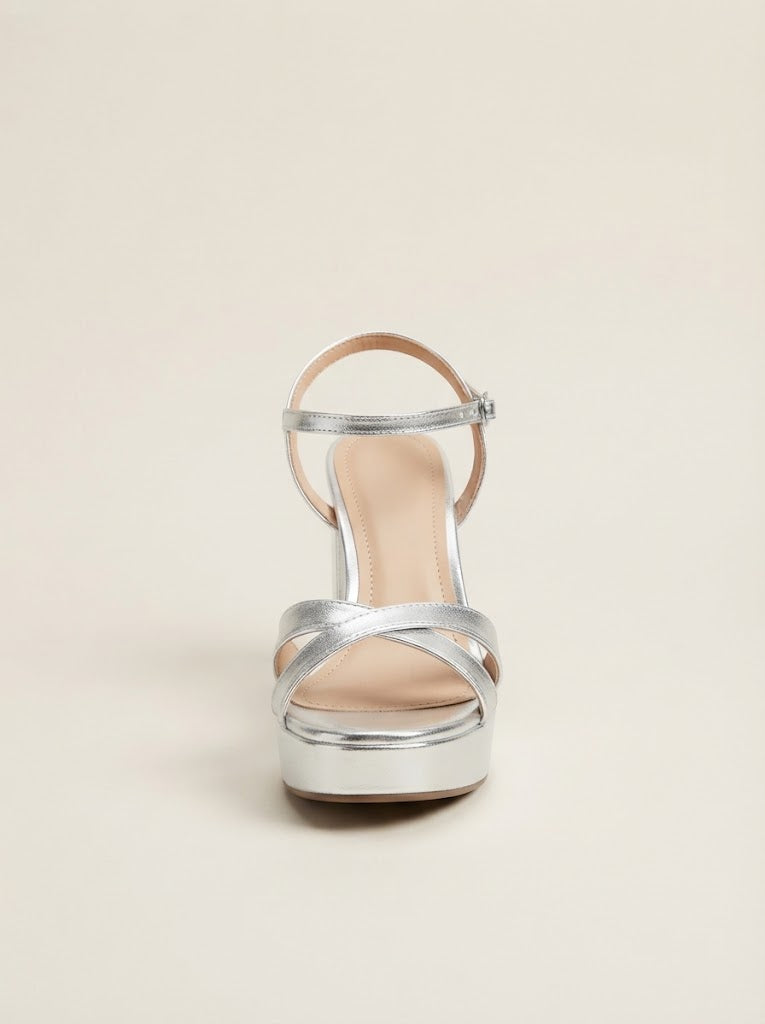 A single metallic silver platform sandal with a thin ankle strap and crisscross front straps, shown from the back on a light beige background.