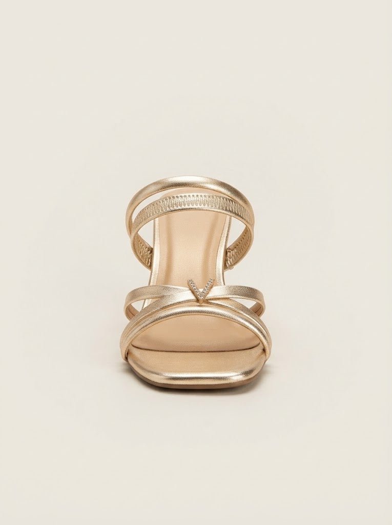 A single metallic gold strappy sandal with a low block heel, shown from a top-down view on a light beige background.