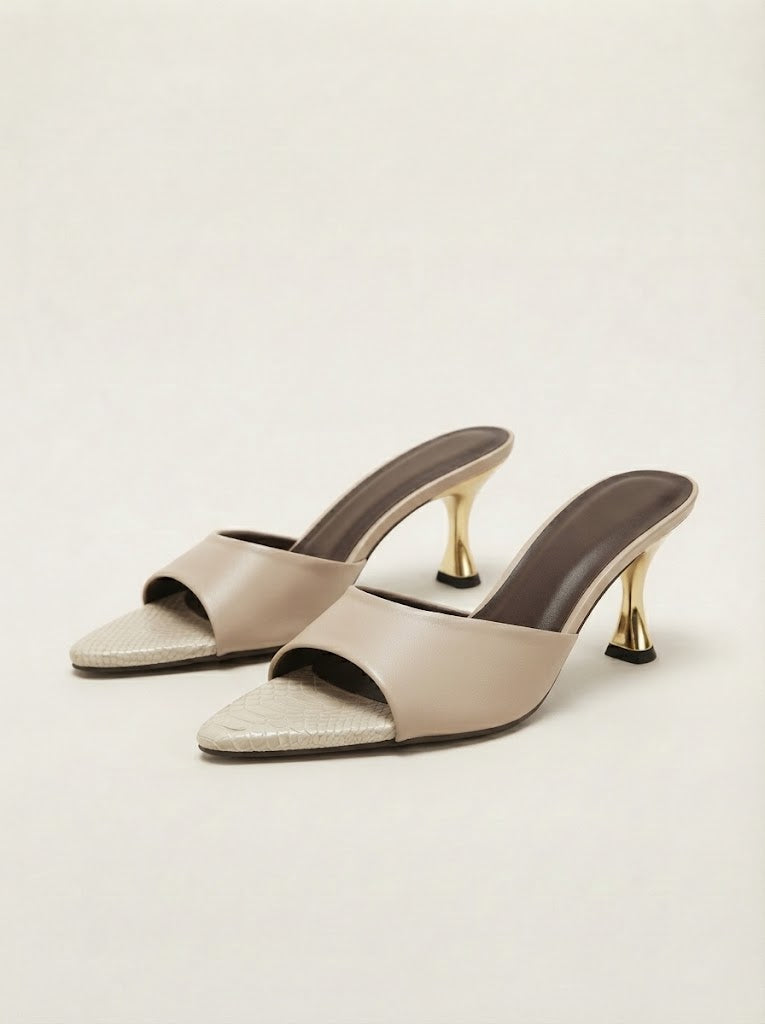 A pair of women's open-toe mule heels in a light taupe-beige color with a metallic glitter toe cap and slim gold stiletto heels, shown against a plain off-white background.